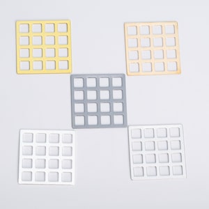 May include: Five square metal mesh sheets in different colors: gold, silver, white, black, and gray. Each sheet has a grid pattern with 25 small squares.