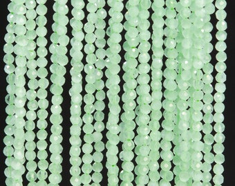 Puede incluir: Una hebra de cuentas facetadas de color verde claro. Las cuentas son pequeñas y redondas, y están enhebradas en un hilo transparente.