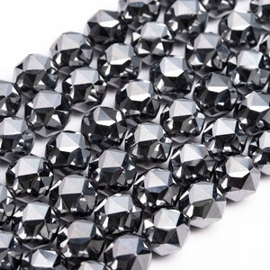 May include: A strand of black faceted gemstone beads. The beads are round and have a shiny, metallic finish.