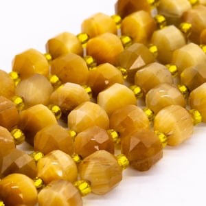 May include: A strand of golden tiger's eye beads with a faceted, hexagonal shape. The beads are strung on a clear elastic cord with small, yellow spacer beads.