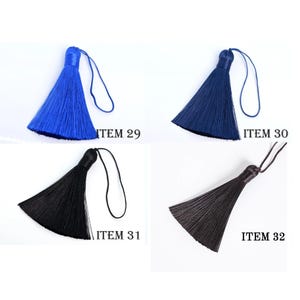 May include: Four colorful tassels in blue, navy, black, and dark brown, each with a looped cord. The tassels are labeled with the item numbers 29, 30, 31, and 32. The tassels are likely for crafts or decorative purposes.