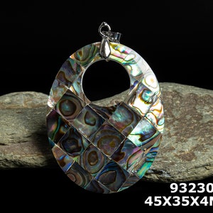 May include: A silver pendant with a large oval-shaped abalone shell inlay. The shell is iridescent with shades of blue, green, and brown. The pendant measures 45mm x 35mm x 4mm.