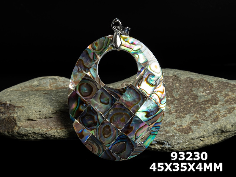May include: A silver pendant with a large oval-shaped abalone shell inlay. The shell is iridescent with shades of blue, green, and brown. The pendant measures 45mm x 35mm x 4mm.