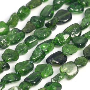 May include: A strand of green gemstone beads, each bead is a smooth, irregular shape. The beads are tumbled and polished, giving them a natural, earthy look.