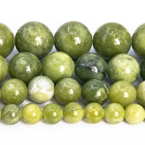 May include: A strand of round, green jade beads. The beads are various shades of green and have a smooth, polished finish.