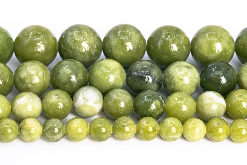 May include: A strand of round, green jade beads. The beads are various shades of green and have a smooth, polished finish.