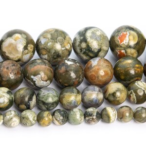 May include: A strand of round, green, brown, and white gemstone beads. The beads have a mottled, speckled pattern.