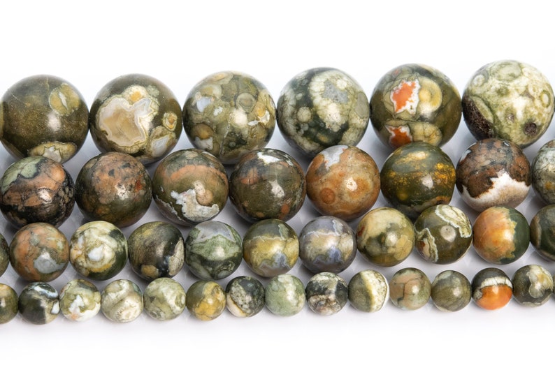 May include: A strand of round, green, brown, and white gemstone beads. The beads have a mottled, speckled pattern.