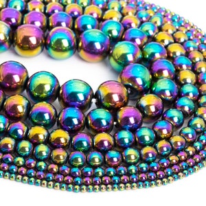 May include: A collection of iridescent rainbow hematite beads in various sizes. The beads are round and smooth, with a metallic sheen.