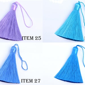 May include: Four colorful tassels in shades of purple, turquoise, and blue. Each tassel has a looped cord and a cylindrical top. The text "ITEM" followed by a number is printed near each tassel.