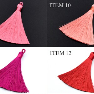 May include: Four silk tassels in different colors: pink, light pink, fuchsia, and red. The tassels are all the same size and shape, and they are hanging from a white background. The tassels are labeled "ITEM 9", "ITEM 10", "ITEM 11", and "ITEM 12".