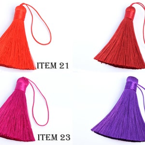 May include: Four colorful tassels in red, burgundy, fuchsia, and purple. Each tassel has a looped string for hanging and is labeled with the text "ITEM" followed by a number. The tassels are made of a silky material.