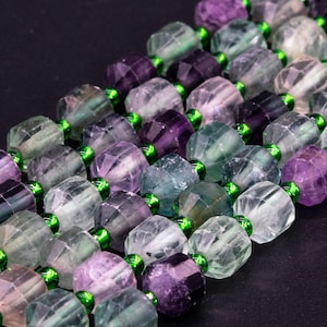 May include: A strand of multi-colored gemstone beads with green spacers. The beads are faceted and have a variety of shades of green, purple, and blue.