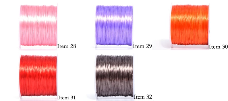 May include: Five spools of colorful elastic cord in pink, purple, orange, red, and gray. Each spool is labeled with an item number. The cords are tightly wound on clear plastic spools, ready for crafting or jewelry making.