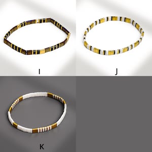 May include: Three beaded necklaces in different color combinations. One necklace features dark brown, gold, and black beads. Another has white, gold, and black beads. The third necklace has white and gold beads.