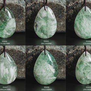 Pu&ograve; includere: Sei ciondoli in fluorite verde e bianca a forma di lacrima. I ciondoli sono infilati su cordini neri e sono esposti su uno sfondo grigio scuro.