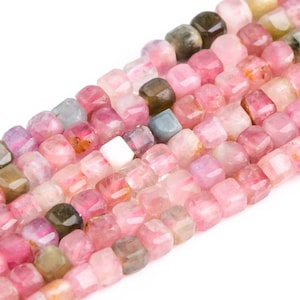 May include: A strand of pink, green, and blue gemstone beads. The beads are faceted and have a square shape.