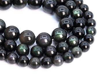 May include: A strand of black obsidian beads with iridescent green and purple highlights. The beads are round and smooth, and they are strung together on a clear thread.