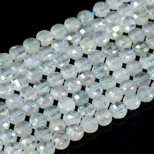 May include: A strand of translucent, faceted, light blue gemstone beads. The beads are round and have a slightly irregular shape.