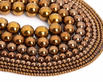 May include: A collection of round, metallic beads in various sizes, ranging from small to large. The beads are a shiny, bronze color and have a smooth, polished finish.