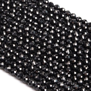 May include: A strand of black faceted beads. The beads are small and round, with a shiny finish.