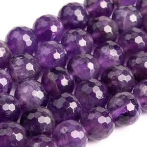 May include: A strand of faceted amethyst beads, each bead is a deep purple color and has a faceted, geometric shape.