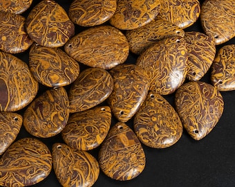 May include: A collection of brown and gold patterned stone pendants. The stones are smooth and have a natural, organic look.