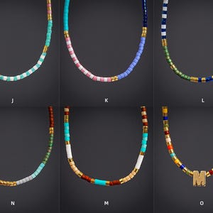May include: Six colorful beaded necklaces with gold accents. The necklaces feature various color combinations, including turquoise, pink, blue, green, and a multi-colored option. One necklace has a gold letter "M".