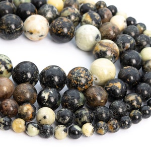 May include: A strand of black, green, and white gemstone beads. The beads are round and have a speckled pattern.