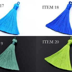 May include: Four tassel trims in different colors: light blue, royal blue, teal green, and lime green. The tassels are all the same size and shape, with a loop at the top for attaching.
