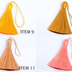 May include: Four colorful tassels in shades of yellow, gold, peach, and coral pink are displayed against a white background. Each tassel has a looped cord and a decorative top. The text "ITEM" followed by a number is printed next to each tassel.