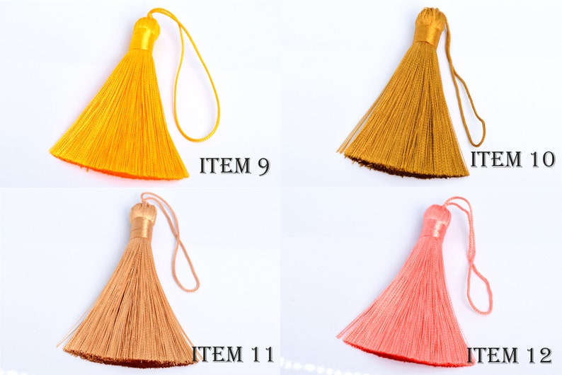 May include: Four colorful tassels in shades of yellow, gold, peach, and coral pink are displayed against a white background. Each tassel has a looped cord and a decorative top. The text "ITEM" followed by a number is printed next to each tassel.