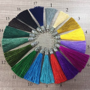 May include: A colour chart of 17 different tassel styles with silver metal tops. The tassels are arranged in a circle, with the numbers 1 through 17 printed next to each tassel.