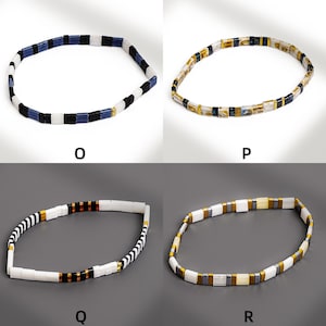 May include: Four necklaces with geometric designs. One necklace features blue, black, and white rectangular beads. Another has gold, black, and white rectangular beads. The other two necklaces have similar designs with different color combinations.