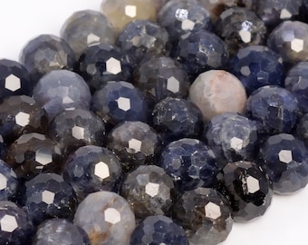 May include: A strand of dark blue faceted gemstone beads. The beads are round and have a slightly irregular shape.
