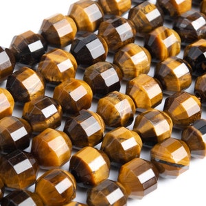 May include: A strand of faceted tiger's eye beads in shades of brown and gold. The beads are arranged in a row and have a polished, shiny finish.