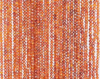 May include: A strand of orange gemstone beads. The beads are faceted and have a shiny, polished finish.