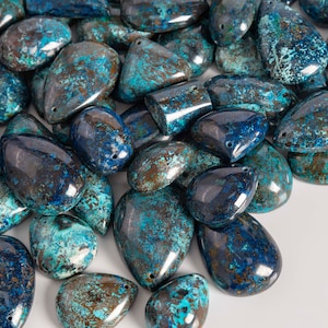 May include: A collection of blue and green gemstone pendants with a mottled, marbled appearance. The pendants are teardrop shaped and have a smooth, polished finish.