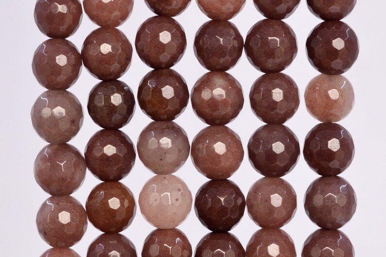 Puede incluir: Una hebra de cuentas de piedras preciosas facetadas en tonos marrones y rosados. Las cuentas son redondas y tienen un acabado liso y pulido.