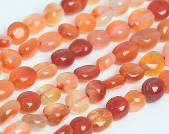 Puede incluir: Una hebra de cuentas de piedra de cornalina en varios tonos de naranja y rojo. Las cuentas son lisas y pulidas, con un acabado natural y pulido.