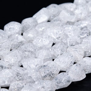 May include: A strand of clear quartz crystal beads with a rough, tumbled finish. The beads are irregularly shaped and have a translucent, milky appearance.