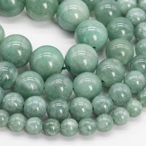 May include: A strand of light green jade beads of various sizes. The beads are round and smooth, with a polished finish.