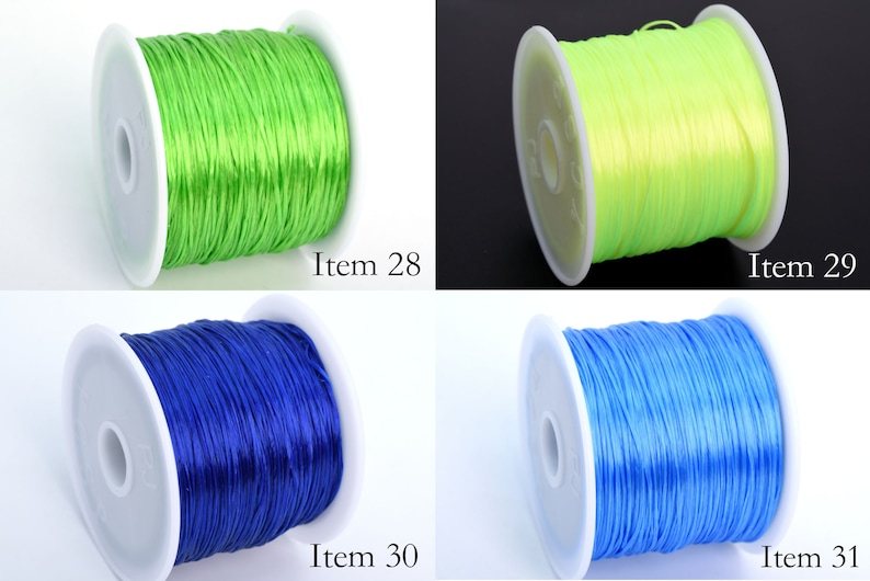 May include: Four spools of elastic cord in different colors: green, yellow, blue, and light blue. Each spool is labeled with an item number.