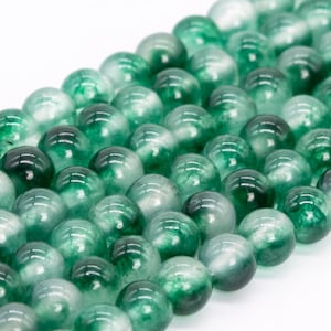 May include: A strand of green and white jade beads. The beads are round and have a smooth, polished finish.