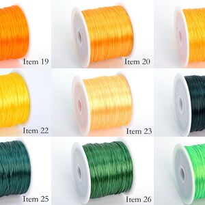 May include: Nine spools of elastic cord in various colors, including orange, yellow, green, and lime green. Each spool is labeled with an item number from 19 to 27.