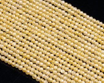 May include: Close-up of strands of faceted, pale yellow gemstone beads. The beads are small, round, and evenly sized, creating a consistent pattern. The beads are strung together, forming multiple parallel lines. The background is black.