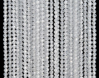 May include: A strand of white faceted glass beads. The beads are round and have a smooth, polished finish.