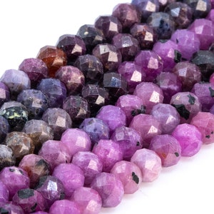 May include: A strand of faceted gemstone beads in shades of purple, pink, and black. The beads are round and have a slightly irregular shape.