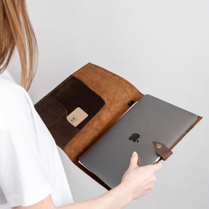 This leather padfolio works as an organizer. It holds 13in laptops and a legal pad. It has a pen and a business card holder. It also holds loose papers.