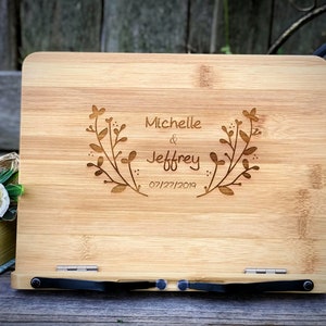 May include: A wooden book stand with a personalized inscription. The inscription reads "Michelle & Jeffrey 07/27/2019" with a floral design.